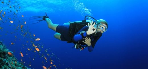 Schöne blonde Frau beim Tauchen zeigt das OK-Tauchzeichen