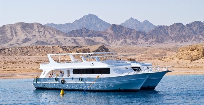 Zwei Safari-Boote verankert In der Bucht in der Nähe einsame Ufer